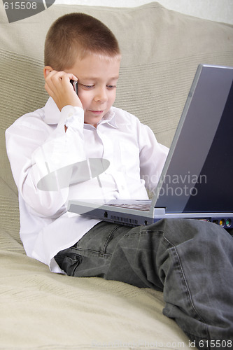 Image of Boy with laptop talking by phone