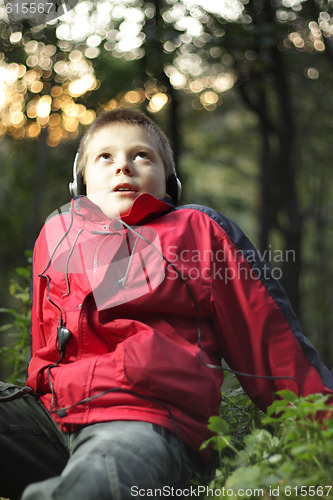 Image of Boy in forest listening music