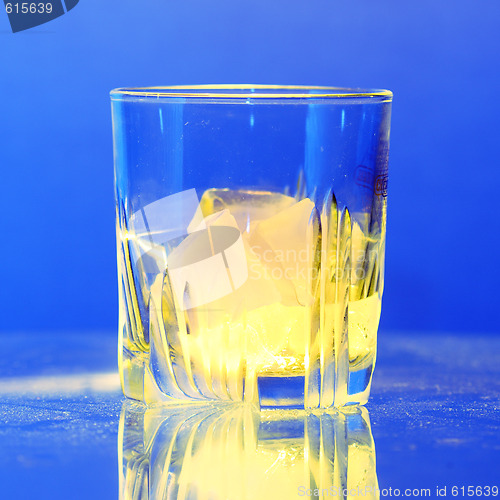 Image of Whiskey glass with burning ice on dusty table