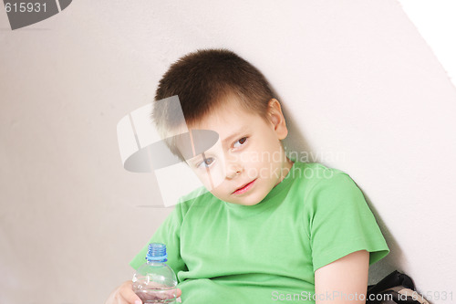 Image of Boy resting under wall