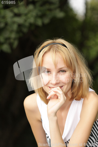 Image of Smiling blonde with hand at face