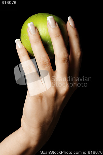 Image of Green apple in manicured hand