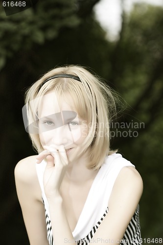 Image of Smiling blonde with hand at nose