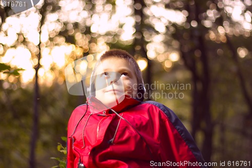 Image of Boy listening music in forest