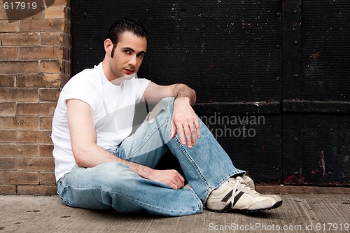 Image of Man sitting on concrete