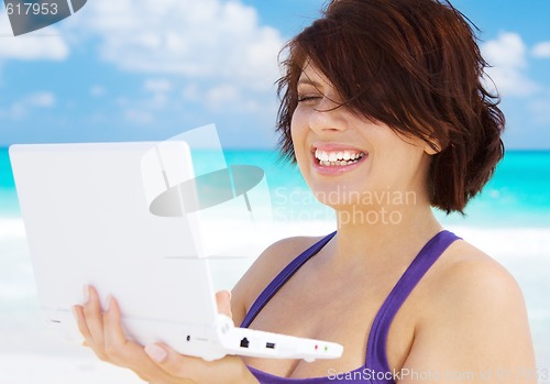 Image of woman with laptop computer on the beach