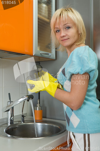 Image of Young woman washing dishes