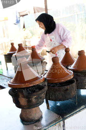 Image of muslim woman cooking food in tagine morocco