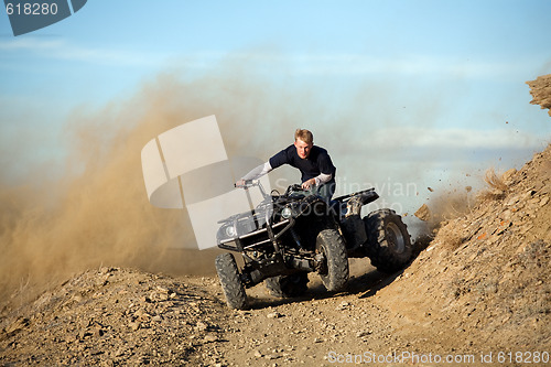 Image of teen riding quad ATV in hills