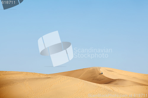 Image of two people walking in desert dunes