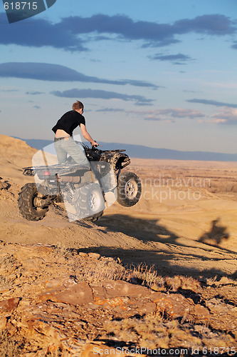 Image of Teen jumping on quad ATV