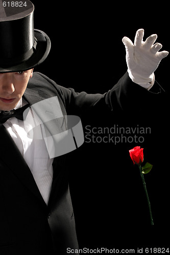 Image of young magician performing red rose