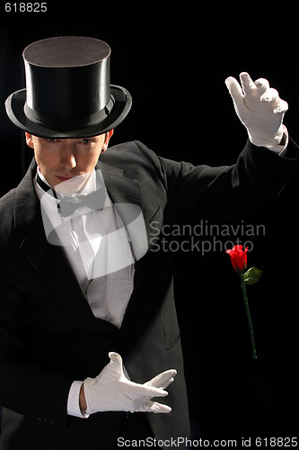 Image of young magician performing red rose