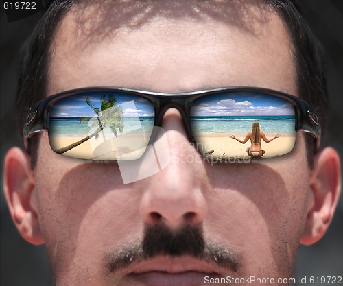 Image of Man Looking at a Woman on the Beach Through Sunglasses