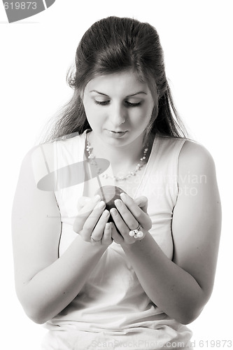 Image of beautiful girl looks at apple on palms