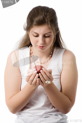 Image of beautiful girl looks at apple on palms