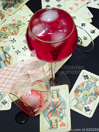 Image of Broken glass, wine with ice and cards