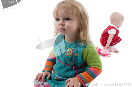 Image of Two babyes sitting on the floor