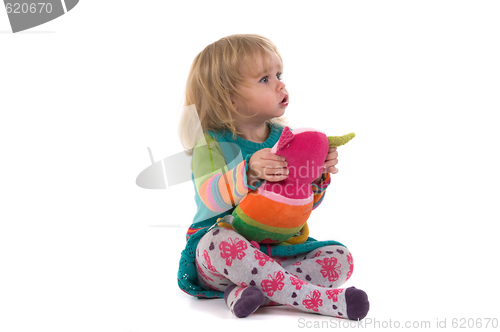 Image of Baby with toy sitting on the floor