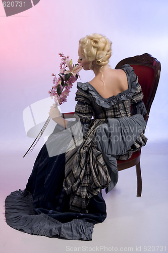 Image of Beautiful woman sitting on a chair with flowers