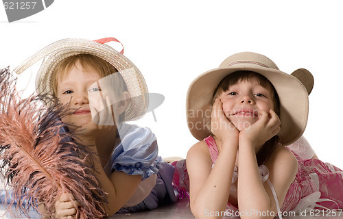 Image of little girls in hats lie on the floor and smile