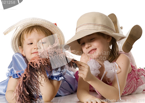 Image of Little girls in hats lie on  floor