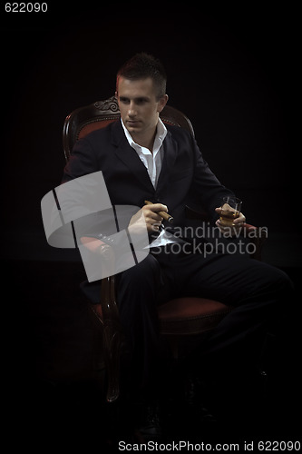 Image of Handsome young man smoking cigar