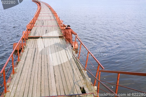 Image of fisherman in brown raincoat
