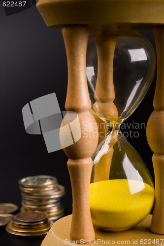 Image of sand clock and coins