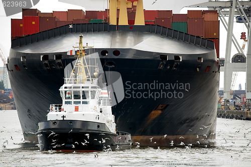 Image of tugboat towing freighter in harbor