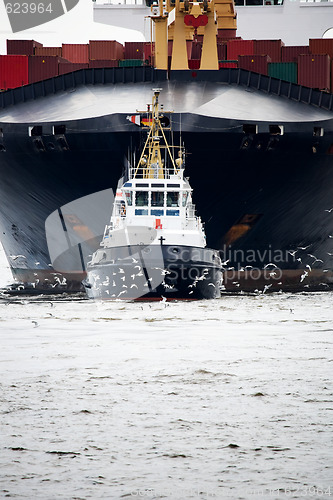 Image of tugboat pulling freighter