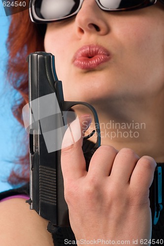 Image of redhaired woman with pistol