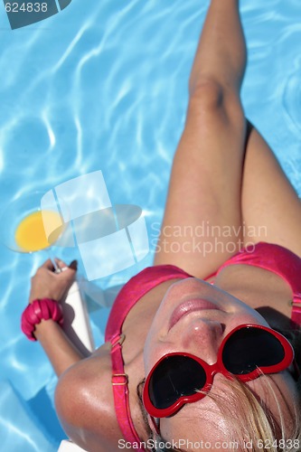 Image of Woman by pool with cocktail