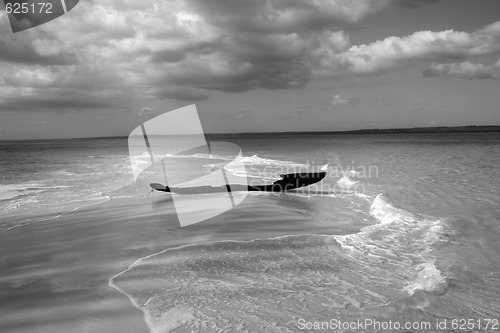Image of ruined fisherman boat on sandy shielf - monochrome
