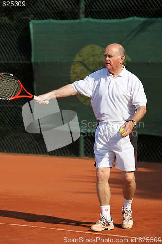 Image of a aktive senior is playing tennis