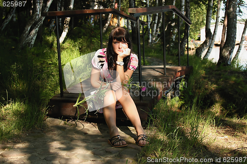 Image of The thoughtful girl with a thistle in hands