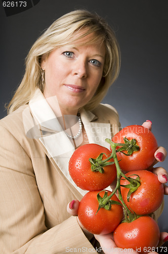 Image of woman with bunch of fresh ripe tomatoes