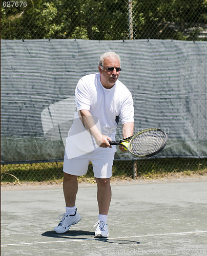 Image of middle age tennis player forehand on court