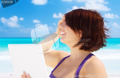 Image of woman with laptop computer on the beach