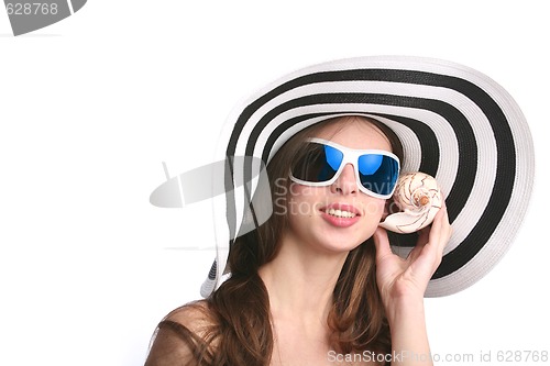 Image of beautiful woman listens seashell