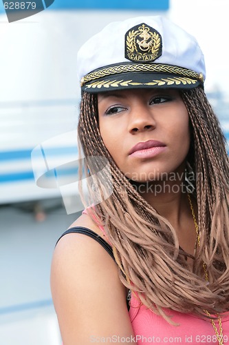 Image of young woman in red tanktop and captain cap