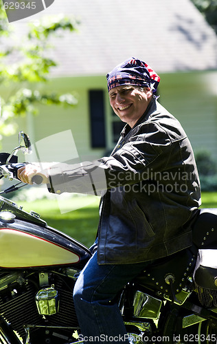 Image of middle age man on motorcycle with american flag bandana