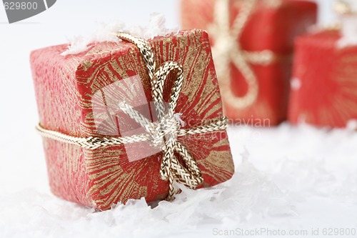 Image of Christmas gifts with red wrapping and decorative bows.