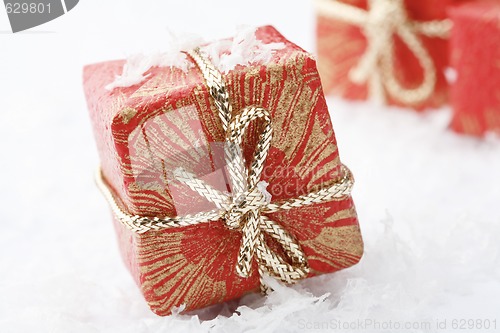 Image of Christmas gifts with red wrapping and decorative bows.