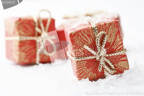 Image of Christmas gifts with red wrapping and decorative bows.