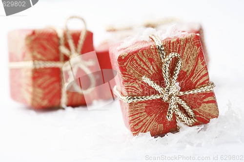 Image of Christmas gifts with red wrapping and decorative bows.