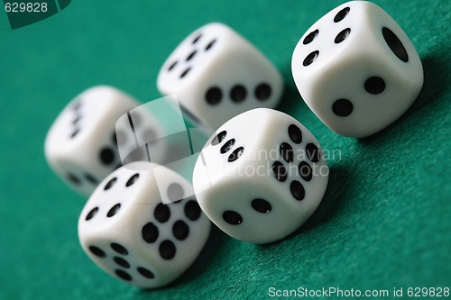 Image of Gambling die on a green surface.