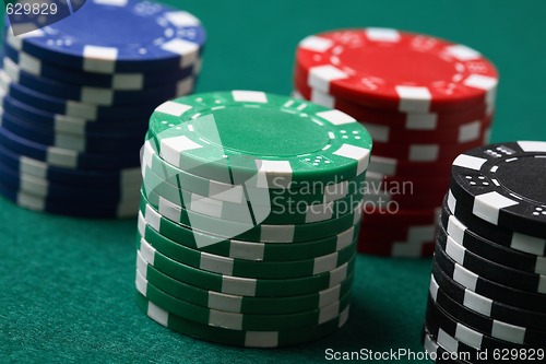 Image of Stacks of poker chips on a green surface.