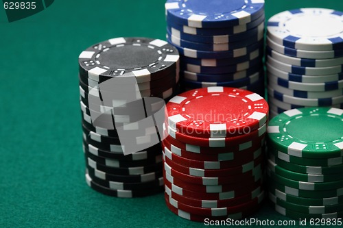 Image of Stacks of poker chips on a green surface.