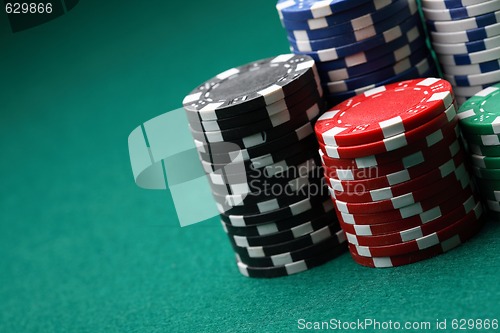 Image of Stacks of poker chips on a green surface.